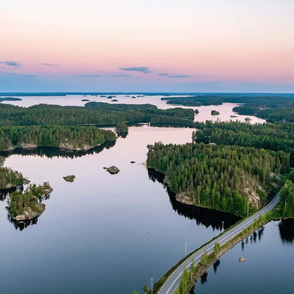 Image of islands, forrests and a road under a sunset.